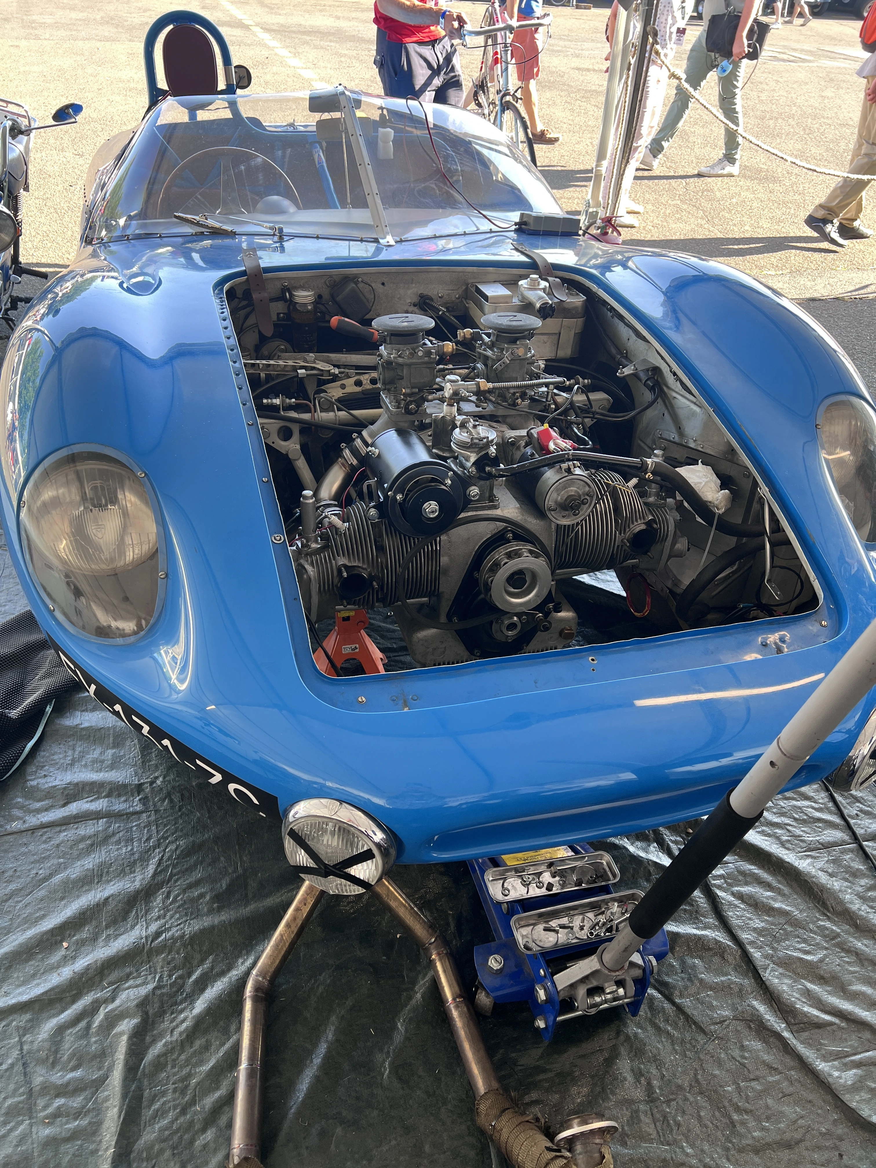 Prototype bleu capot ouvert, moteur accessible en paddock